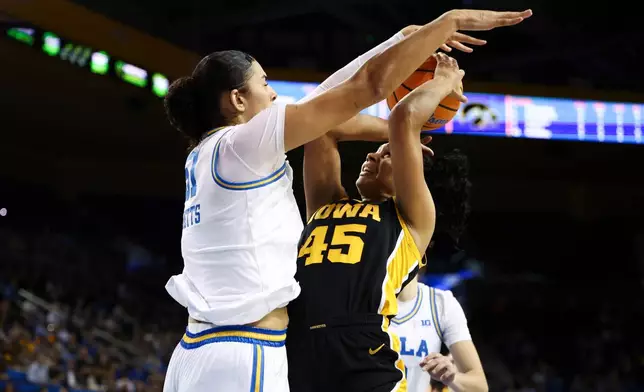 Iowa forward Hannah Stuelke (45) draws a foul against UCLA center Lauren Betts, left, during the first half of an NCAA college basketball game, Sunday, Feb. 1, 2026, in Los Angeles. (AP Photo/Jessie Alcheh)