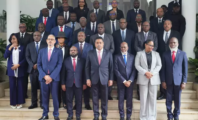 Haiti's Prime Minister Alix Didier Fils-Aimé, front row, left, and his cabinet pose for a group photo with members of the presidential council at a ceremony marking the end of their almost two-year rule, in Port-au-Prince, Saturday, Feb. 7, 2026. (AP Photo/Odelyn Joseph)