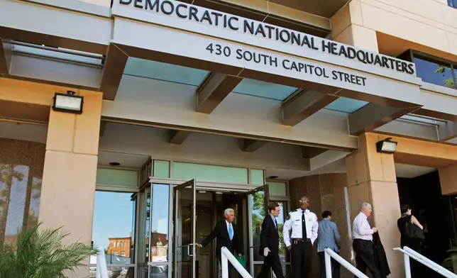 FILE - People stand outside the Democratic National Committee headquarters in Washington, June 14, 2016. (AP Photo/Paul Holston, File)