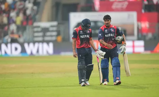 Nepal's Lokesh Bam with batting partner Karan KC walk back to pavilion after losing against England during the T20 World Cup cricket match in Mumbai, India, Sunday,Feb. 8, 2026.(AP Photo/Rafiq Maqbool)