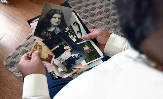 Derrick Johnson, whose mother's body was one of 189 left to decay in the Return to Nature Funeral Home in Penrose, Colo., holds photos of her in Colorado Springs, Colo., on Thursday, Feb. 5, 2026. (AP Photo/Thomas Peipert)