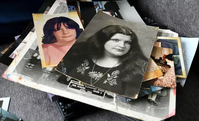 Photographs of Ellen Marie Shriver-Lopes, whose body was one of 189 left to decay in the Return to Nature Funeral Home in Penrose, Colo., are stacked in her sister's home in Colorado Springs, Colo., on Thursday, Feb. 5, 2026. (AP Photo/Thomas Peipert)