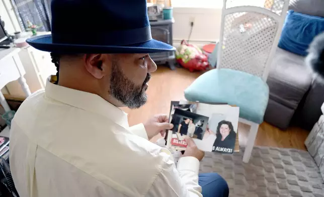 Derrick Johnson, whose mother's body was one of 189 left to decay in the Return to Nature Funeral Home in Penrose, Colo., holds family photos in his aunt's home in Colorado Springs, Colo., on Thursday, Feb. 5, 2026. (AP Photo/Thomas Peipert)
