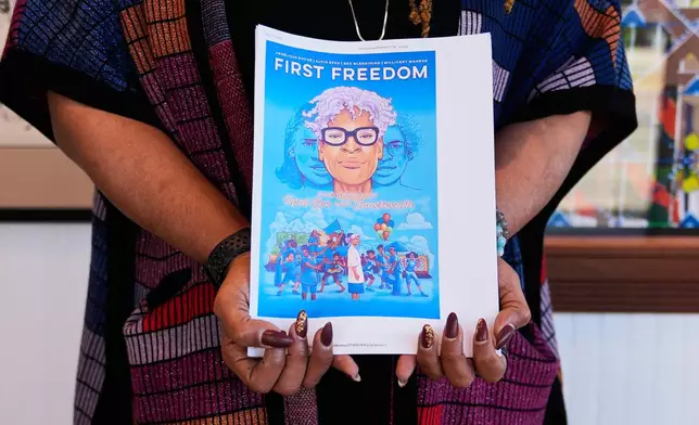 Angelique Roche holds a printout of her upcoming Book "First Freedom: The Story of Opal Lee and Juneteenth," at the Ashe Cultural Arts Center, Thursday, Jan. 29, 2026, in New Orleans. (AP Photo/Gerald Herbert)