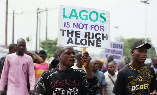 Victor Ahansu, center, protests the recent mass evictions and demolition of homes in Makoko and other communities, in Lagos, Nigeria, Wednesday, Jan. 28, 2026. (AP Photo/Sunday Alamba)