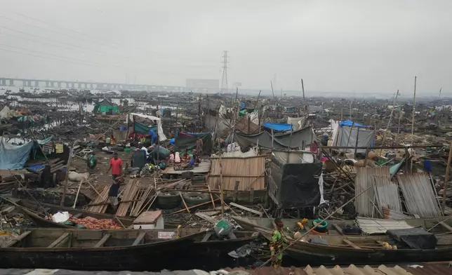 People stand on the ruins of their demolished stilts houses by authorities at Makoko slum in Lagos, Nigeria, Wednesday, Jan. 14, 2026. (AP Photo/Sunday Alamba)