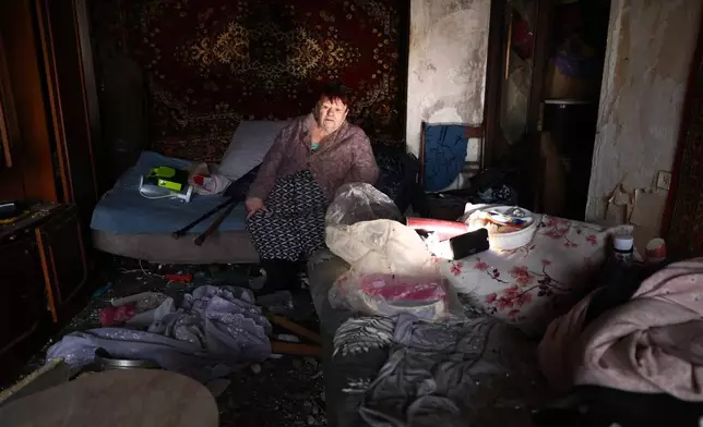 An elderly woman sits in her damaged apartment after a Russian drone hit an apartment building in Zaporizhzhia, Ukraine, Thursday, Feb. 26, 2026. (AP Photo/Kateryna Klochko)