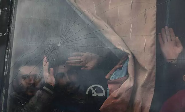 Syrian government prisoners wave from a bus after their release in a prisoner exchange between Syrian government forces and Druze militiamen in Sweida province, Syria, Thursday, Feb. 26, 2026. (AP Photo/Ghaith Alsayed)