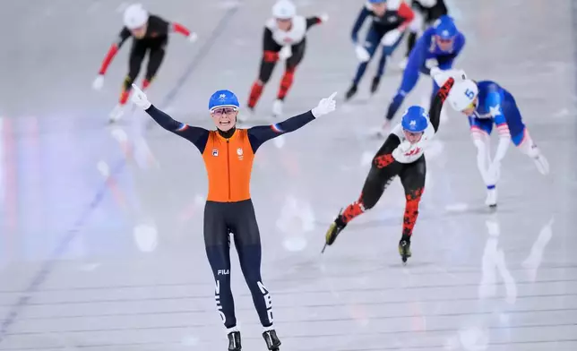Marijke Groenewoud of the Netherlands celebrates winning the gold medal ahead of Ivanie Blondin of Canada, center right and silver medal, and Mia Manganello of the U.S., far right and bronze medal, in the women's mass start final speedskating race at the 2026 Winter Olympics, in Milan, Italy, Saturday, Feb. 21, 2026. (AP Photo/Luca Bruno)