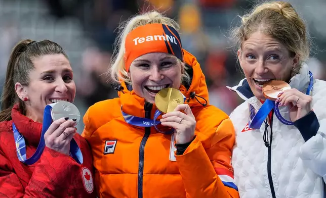 Marijke Groenewoud of the Netherlands, center and gold medal, Ivanie Blondin of Canada, left and silver medal, and Mia Manganello of the U.S., right and bronze medal, celebrate on the podium of the mass start speedskating race at the 2026 Winter Olympics, in Milan, Italy, Saturday, Feb. 21, 2026. (AP Photo/Luca Bruno)