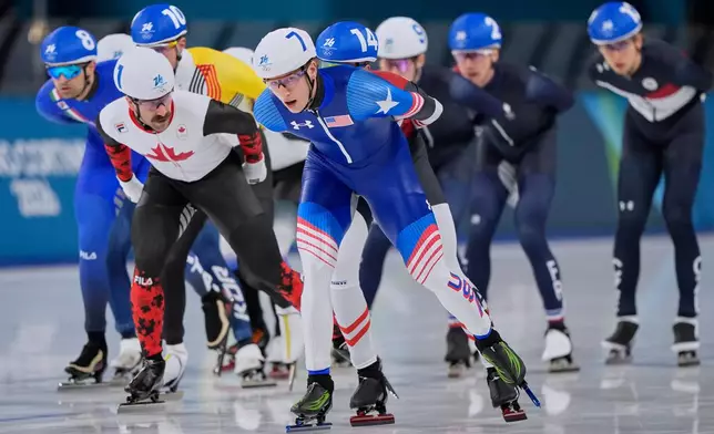 Jordan Stolz of the U.S., center, Antoine Gelinas-Beaulieu of Canada, left, and Andrea Giovannini of Italy, far left, compete in the men's mass start final speedskating race at the 2026 Winter Olympics, in Milan, Italy, Saturday, Feb. 21, 2026. (AP Photo/Ben Curtis)