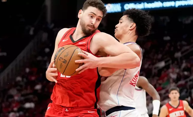 Houston Rockets center Alperen Sengun, left, drives to the basket as Los Angeles Clippers center Yanic Konan Niederhäuser defends during the first half of an NBA basketball game, Wednesday, Feb. 11, 2026, in Houston. (AP Photo/Eric Christian Smith)