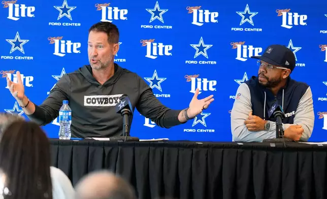 Dallas Cowboys head coach Brian Schottenheimer, left, responds to questions as Christian Parker looks on during a news conference where Parker was introduced as the new defensive coordinator for the NFL football team, Wednesday, Feb. 18, 2026, in Frisco, Texas. (AP Photo/Tony Gutierrez)