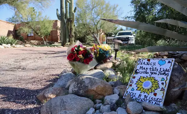 A memorial grows outside the home of Nancy Guthrie, the missing mother of "Today" show host Savannah Guthrie, in Tucson, Ariz., Sunday, Feb. 22, 2026. (AP Photo/Felicia Fonseca)