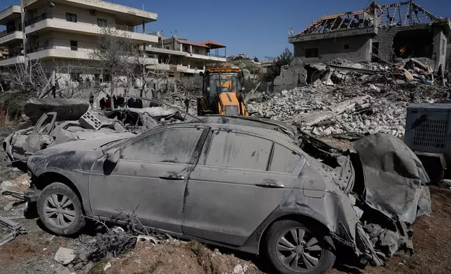 People gather near a building destroyed in an Israeli strike in the village of Bednayel in eastern Lebanon, Saturday, Feb. 21, 2026. (AP Photo/Bilal Hussein)