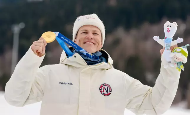Gold medalist Johannes Hoesflot Klaebo, of Norway, poses on the podium of the cross-country skiing men's sprint classic at the 2026 Winter Olympics, in Tesero, Italy, Tuesday, Feb. 10, 2026. (AP Photo/Evgeniy Maloletka)