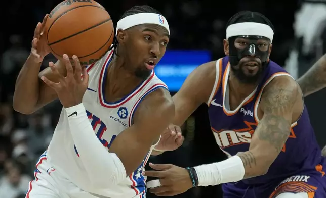 Philadelphia 76ers guard Tyrese Maxey, left, keeps the ball away from Phoenix Suns guard Jordan Goodwin during the first half of an NBA basketball game Saturday, Feb. 7, 2026, in Phoenix. (AP Photo/Ross D. Franklin)