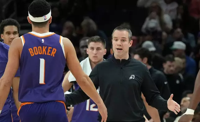 Phoenix Suns head coach Jordan Ott, right, slaps hands with Suns guard Devin Booker (1) during the first half of an NBA basketball game against the Philadelphia 76ers Saturday, Feb. 7, 2026, in Phoenix. (AP Photo/Ross D. Franklin)