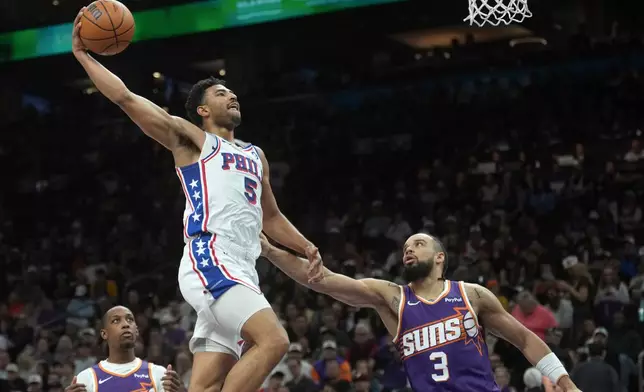 Philadelphia 76ers guard Quentin Grimes (5) is fouled prior to the shot by Phoenix Suns forward Dillon Brooks (3) as Suns guard Jamaree Bouyea, left, looks on during the first half of an NBA basketball game Saturday, Feb. 7, 2026, in Phoenix. (AP Photo/Ross D. Franklin)