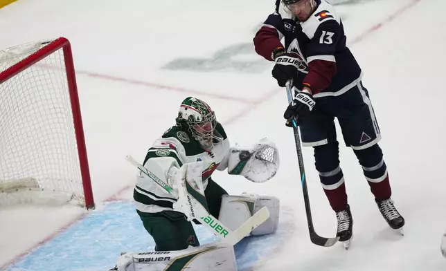 Colorado Avalanche right wing Valeri Nichushkin, right, redirects the puck at Minnesota Wild goaltender Filip Gustavsson, left, in the first period of an NHL hockey game Thursday, Feb. 26, 2026, in Denver. (AP Photo/David Zalubowski)