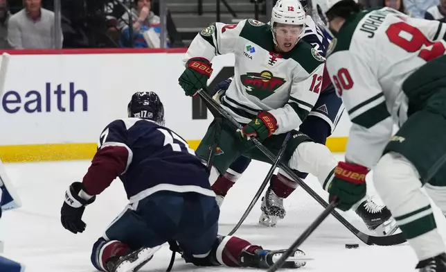 Minnesota Wild left wing Matt Boldy (12) looks to score as Colorado Avalanche center Parker Kelly, left, defends in the second period of an NHL hockey game Thursday, Feb. 26, 2026, in Denver. (AP Photo/David Zalubowski)