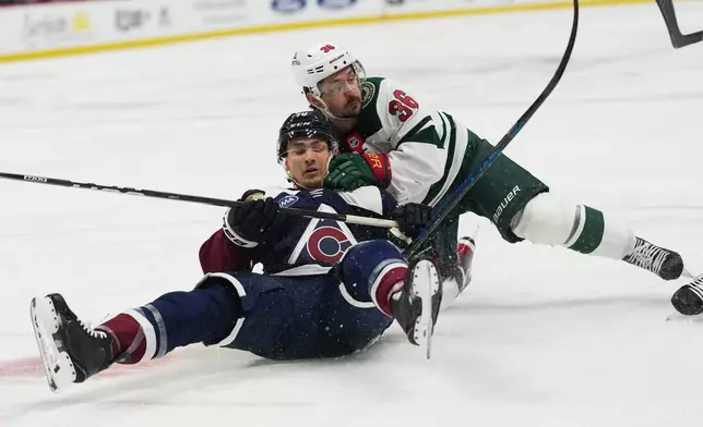 Colorado Avalanche defenseman Sam Malinski, left, tumbles to the ice with Minnesota Wild right wing Mats Zuccarello while pursuing the puck n the second period of an NHL hockey game, Thursday, Feb. 26, 2026, in Denver. (AP Photo/David Zalubowski)