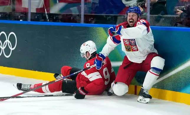 Czechia's Tomas Hertl (48) is challenged by Switzerland's Damien Riat (9) during a preliminary round match of men's ice hockey between Switzerland and Czechia at the 2026 Winter Olympics, in Milan, Italy, Sunday, Feb. 15, 2026. (AP Photo/Petr David Josek)
