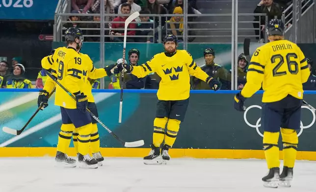 Sweden's William Nylander, center, celebrates after scoring her side's third goal during a preliminary round match of men's ice hockey between Italy and Sweden at the 2026 Winter Olympics, in Milan, Italy, Wednesday, Feb. 11, 2026. (AP Photo/Hassan Ammar)