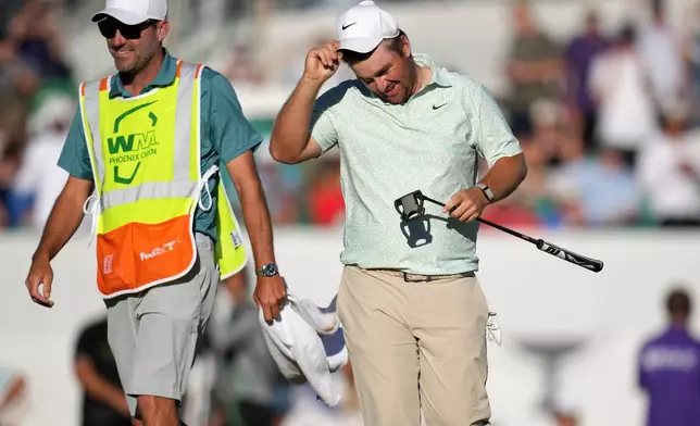 Chris Gotterup, right, smiles along with caddie Brady Stockton after Gotterup's playoff win on the 18th hole during the final round of the Phoenix Open golf tournament Sunday, Feb. 8, 2026, in Scottsdale, Ariz. (AP Photo/Ross D. Franklin)