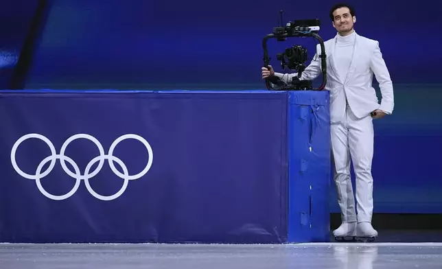Jordan Cowan operates the steadicam before the pairs figure skating short program at the 2026 Winter Olympics, in Milan, Italy, Sunday, Feb. 15, 2026. (AP Photo/Ashley Landis)