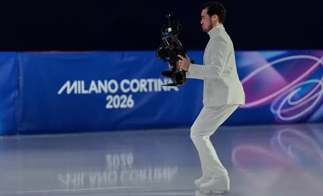 Jordan Cowan operates the steadicam before the pairs figure skating short program at the 2026 Winter Olympics, in Milan, Italy, Sunday, Feb. 15, 2026. (AP Photo/Ashley Landis)