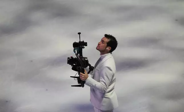 Jordan Cowan operates the steadicam before the pairs figure skating short program at the 2026 Winter Olympics, in Milan, Italy, Sunday, Feb. 15, 2026. (AP Photo/Stephanie Scarbrough)