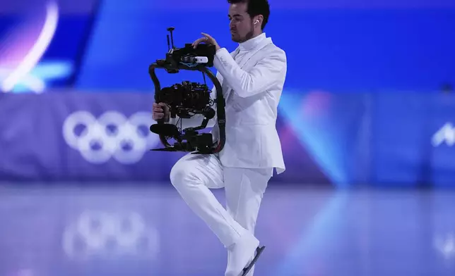 Jordan Cowan operates the steadicam before the pairs figure skating short program at the 2026 Winter Olympics, in Milan, Italy, Sunday, Feb. 15, 2026. (AP Photo/Ashley Landis)