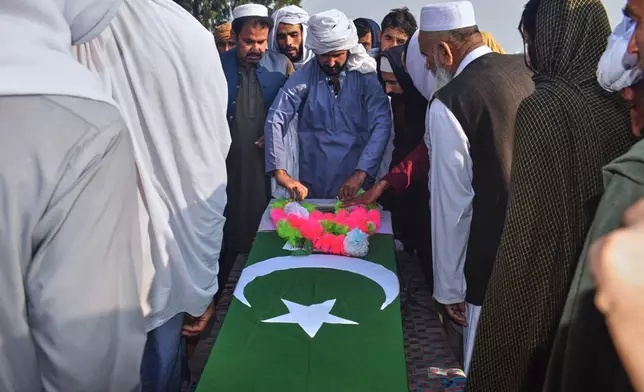 People gather around the coffin of an army soldier, killed in the cross-border clashes of Pakistan and Afghan forces, during a funeral prayer in a village in Lakki Marwat, a district of Pakistan's Khyber Pakhtunkhwa province, Saturday, Feb. 28, 2026. (AP Photo/G.A. Marwat)