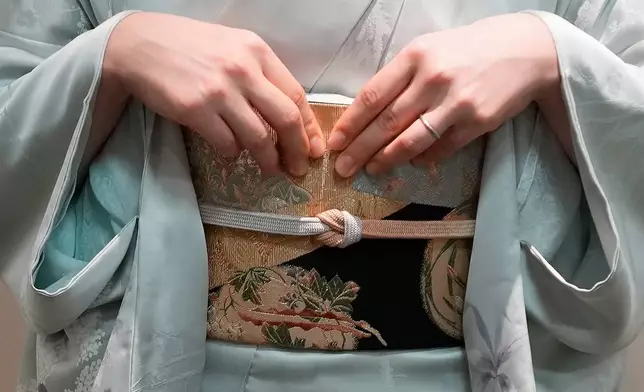 A woman displays a kimono in Tokyo Tuesday, Nov. 11, 2025. (AP Photo/Eugene Hoshiko)