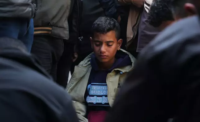 A youth mourns over the body of a Palestinian policeman, Khaled Al-Zayan, who was killed in an Israeli military strike, during his funeral in Khan Younis, southern Gaza Strip, Friday, Feb. 27, 2026. (AP Photo/Abdel Kareem Hana)