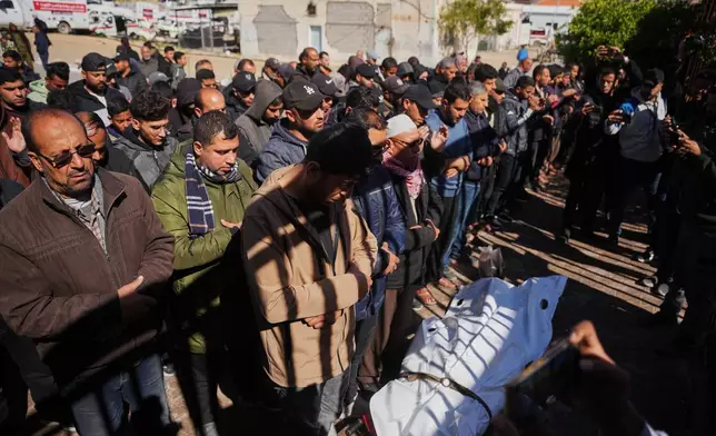 Mourners pray over the body of a Palestinian policeman who was killed in an Israeli military strike, at Nasser Hospital, in Khan Younis, southern Gaza Strip, Friday, Feb. 27, 2026. (AP Photo/Abdel Kareem Hana)
