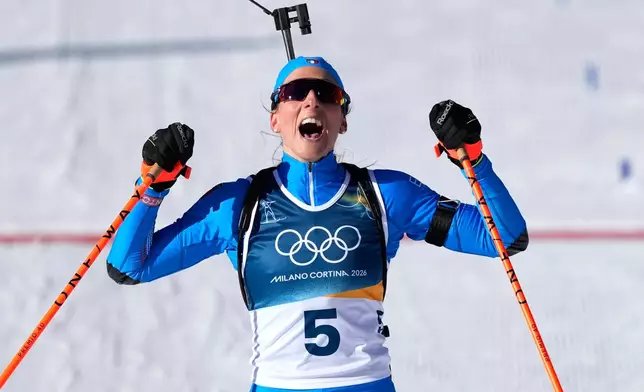 Lisa Vittozzi, of Italy, reacts after crossing the finish line to win gold during the women's 10-kilometer pursuit biathlon race at the 2026 Winter Olympics in Anterselva, Italy, Sunday, Feb. 15, 2026. (AP Photo/Mosa'ab Elshamy)