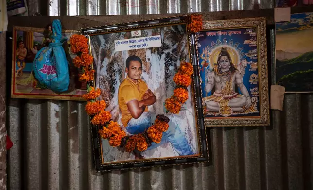 A portrait of Dipu Chandra Das hangs alongside images of Hindu deities inside his home in Tarakanda village, Mymensingh District, Bangladesh, Jan. 9, 2026. (AP Photo/Mahmud Hossain Opu)