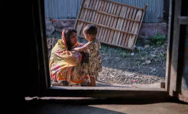 Meghna Rani, wife of Dipu Chandra Das, plays with her daughter outside their home in Tarakanda village, Mymensingh District, Bangladesh, Jan. 9, 2026. (AP Photo/Mahmud Hossain Opu)