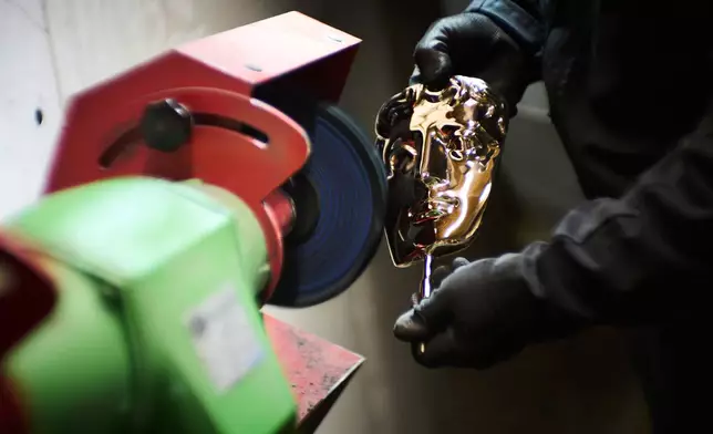 A British Academy Film Awards mask is polished as part of the process to create BAFTA masks at FSE Foundry in Braintree, England on Tuesday, Feb. 10, 2026. (Scott A Garfitt/Invision/AP)
