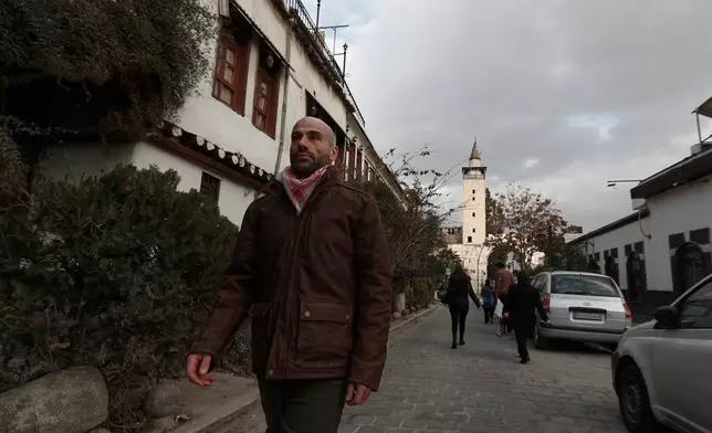 Hani Al Sawah, a Syrian rap artist known as Al Darwish, walks at a street in old Damascus, Syria, Friday, Jan. 16, 2026. (AP Photo/Omar Sanadiki)