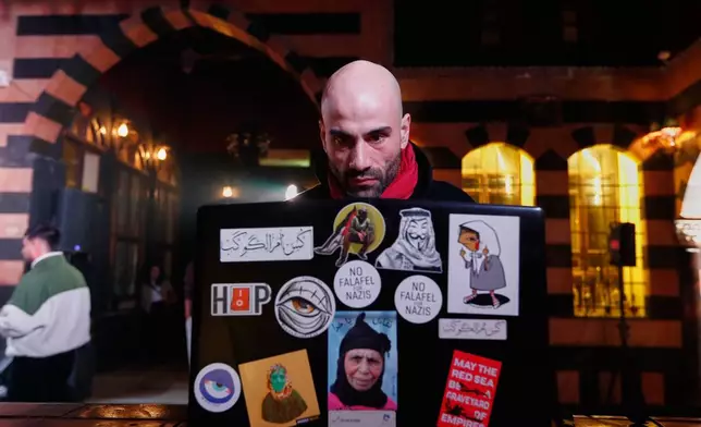 Hani Al Sawah, a Syrian rap artist known as Al Darwish, works on his laptop in old Damascus, Syria, Friday, Jan. 16, 2026. (AP Photo/Omar Sanadiki)