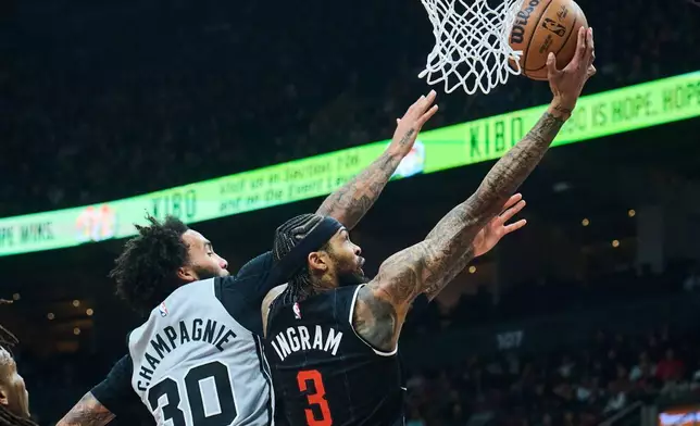 Toronto Raptors' Brandon Ingram (3) drives to the net past San Antonio Spurs' Julian Champagnie (30) during the first half of an NBA basketball game in Toronto, Wednesday, Feb. 25, 2026. (Sammy Kogan/The Canadian Press via AP)