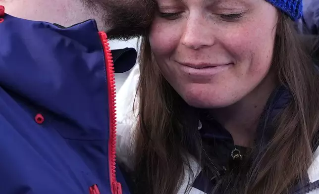United States' Breezy Johnson, right, is kissed by fiancee Connor Watkins as they are interviewed after he proposed to her at the end of an alpine ski, women's super-G race, at the 2026 Winter Olympics, in Cortina d'Ampezzo, Italy, Thursday, Feb. 12, 2026. (AP Photo/Jacquelyn Martin)
