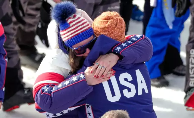 United States' Breezy Johnson hugs Connor Watkins, at the finish area of an alpine ski, women's super-G race, at the 2026 Winter Olympics, in Cortina d'Ampezzo, Italy, Thursday, Feb. 12, 2026. (AP Photo/Andy Wong)