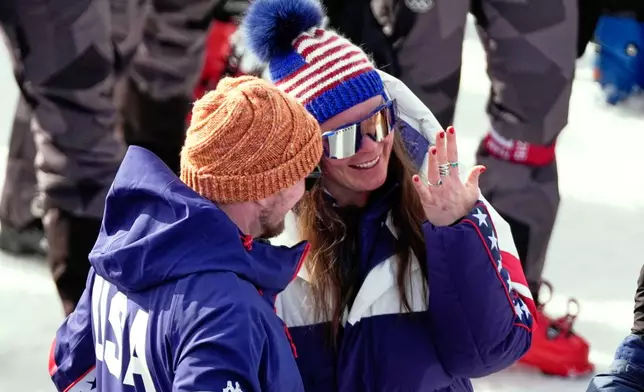 United States' Breezy Johnson looks at the engagement ring she was given by Connor Watkins, at the finish area of an alpine ski, women's super-G race, at the 2026 Winter Olympics, in Cortina d'Ampezzo, Italy, Thursday, Feb. 12, 2026. (AP Photo/Andy Wong)