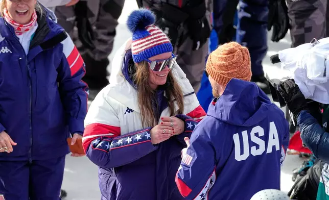United States' Breezy Johnson touches the engagement ring she was given by Connor Watkins, at the finish area of an alpine ski, women's super-G race, at the 2026 Winter Olympics, in Cortina d'Ampezzo, Italy, Thursday, Feb. 12, 2026. (AP Photo/Andy Wong)