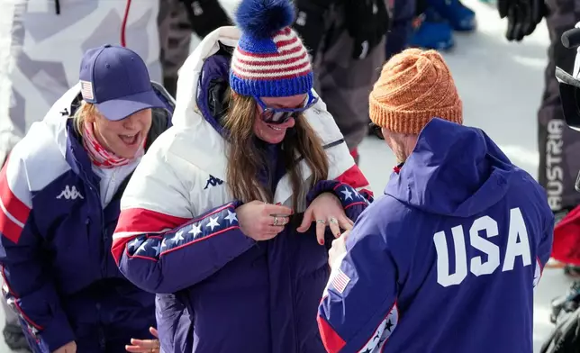 United States' Breezy Johnson looks at the engagement ring she was given by Connor Watkins, at the finish area of an alpine ski, women's super-G race, at the 2026 Winter Olympics, in Cortina d'Ampezzo, Italy, Thursday, Feb. 12, 2026. (AP Photo/Andy Wong)
