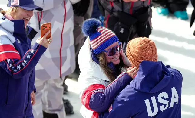 United States' Breezy Johnson looks at Connor Watkins after being given an engagement ring, at the finish area of an alpine ski, women's super-G race, at the 2026 Winter Olympics, in Cortina d'Ampezzo, Italy, Thursday, Feb. 12, 2026. (AP Photo/Andy Wong)